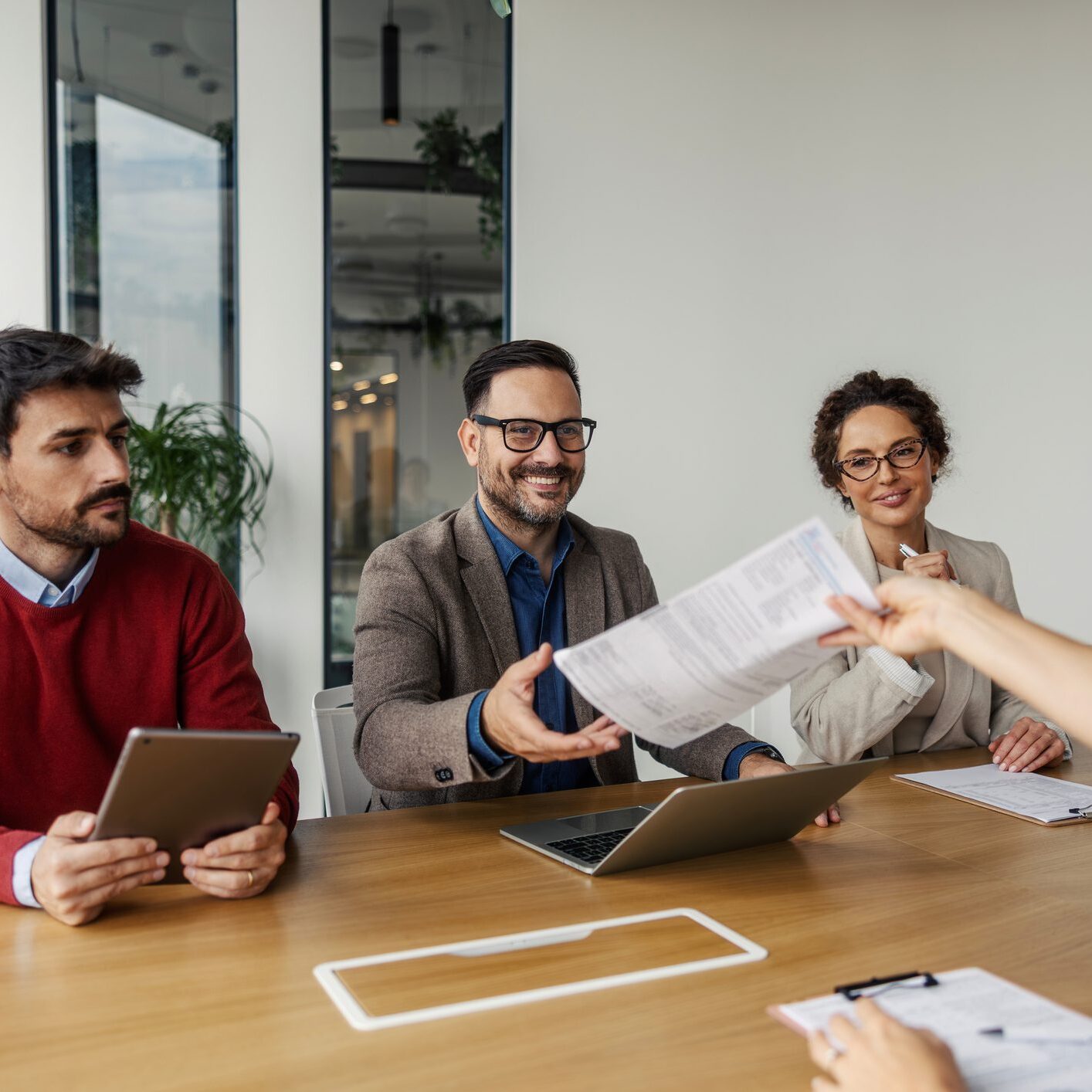 Recruiters and human resources professionals interviewing a young adult candidate, evaluating qualifications for a new professional career opportunity in a modern office